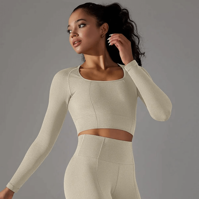 Woman modeling seamless bodycon crop top with long sleeves, ideal for yoga and running.